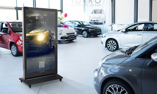 Floorstanding digital sign displayed in a car showroom